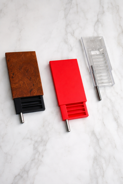 Three Hide-a-Lines with different colors,   walnut, red, and clear, on a marble surface
